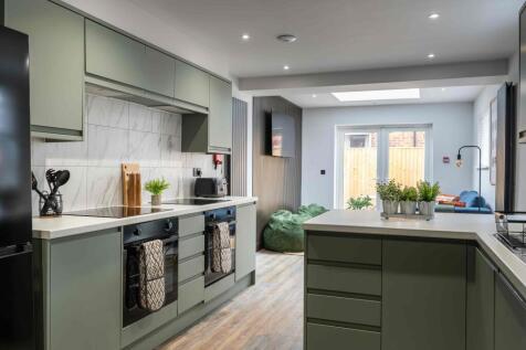 Bright and modern kitchen with sleek green cabi...