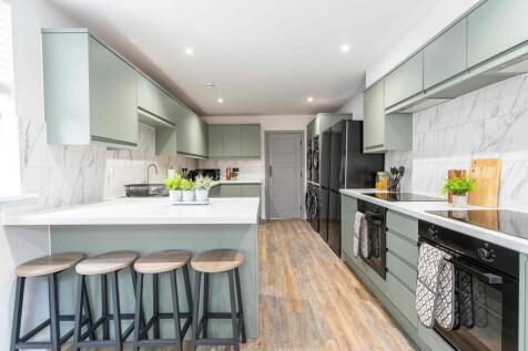 Modern and sleek kitchen with sage green cabine...