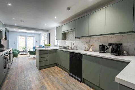Modern and bright kitchen with sleek green cabi...