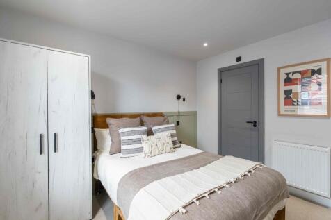 A cozy double bedroom featuring a neatly made b...