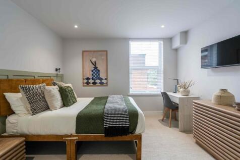 Bright and stylish master bedroom featuring a c...