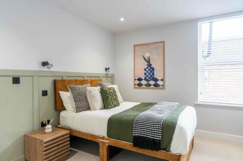 A spacious, stylish bedroom with a large double...