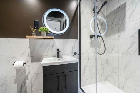 Modern bathroom featuring a stylish round illum...