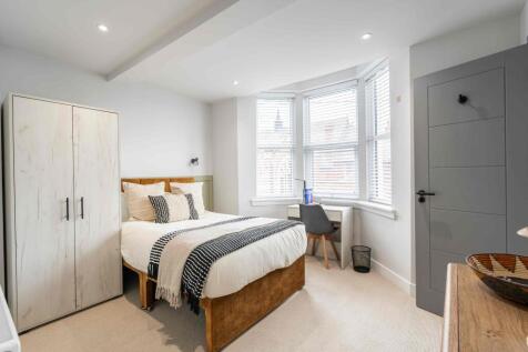 Bright and modern bedroom featuring a comfortab...