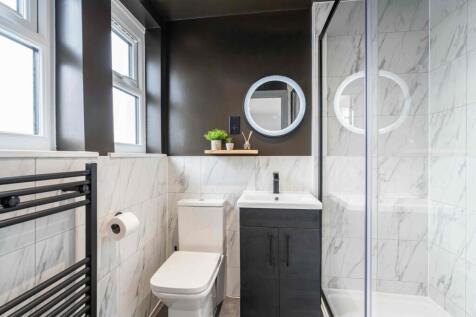 Modern bathroom featuring sleek white marble ti...
