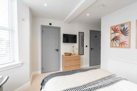A bright, modern bedroom with clean white walls...