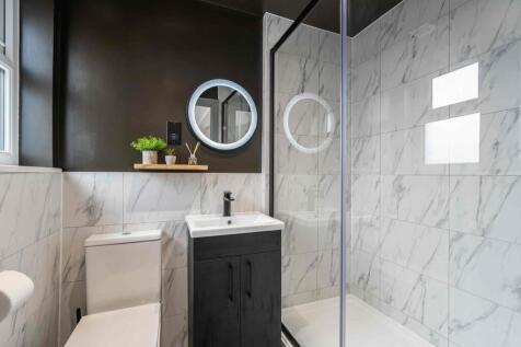 Modern bathroom featuring marble tiles, a sleek...