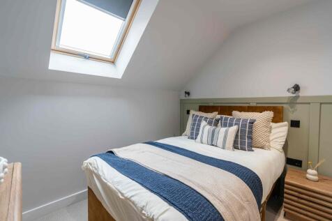 A bright and welcoming master bedroom featuring...
