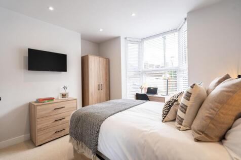 Bright and modern bedroom featuring a large win...