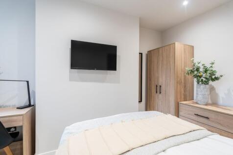 A bright and modern bedroom featuring a mounted...