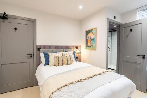 A stylish master bedroom featuring a comfortabl...