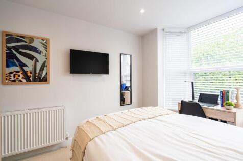 A bright and modern bedroom featuring a large w...