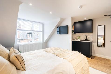 Bright and modern bedroom featuring a large bed...