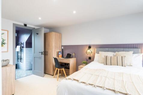 A spacious and well-lit master bedroom featurin...