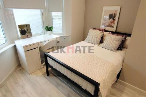 A bright and stylish double bedroom featuring a...