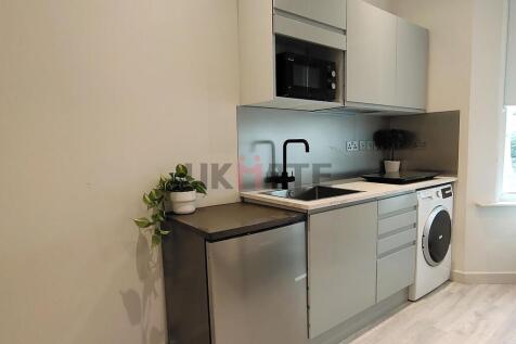Modern kitchen featuring sleek cabinetry, a bui...