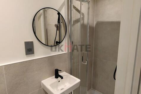 A modern, clean bathroom featuring a small sink...