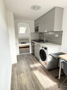 Modern and compact kitchen with sleek gray cabi...