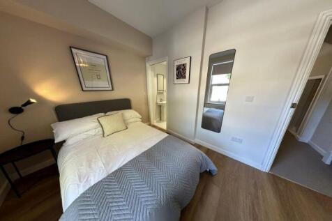 A cozy and well-maintained bedroom with a bed, ...
