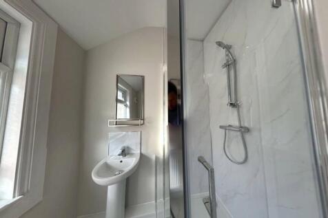 A modern, clean bathroom featuring a shower wit...