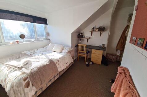 Cozy single bedroom featuring a large window th...