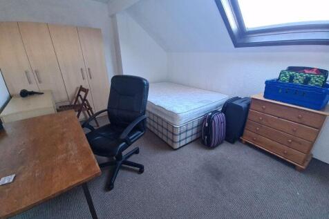 A cozy single bedroom with a large skylight win...