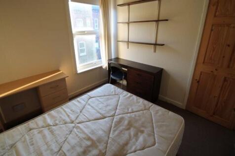 Cozy single bedroom featuring a large window th...