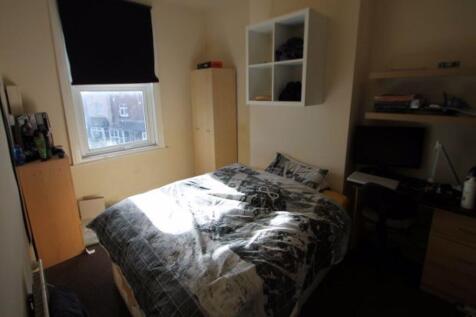 A well-lit bedroom featuring a spacious double ...