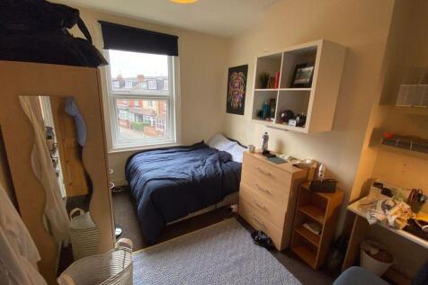 A cozy student bedroom featuring a double bed p...