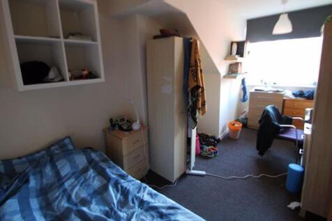 A cozy bedroom featuring a single bed with a bl...