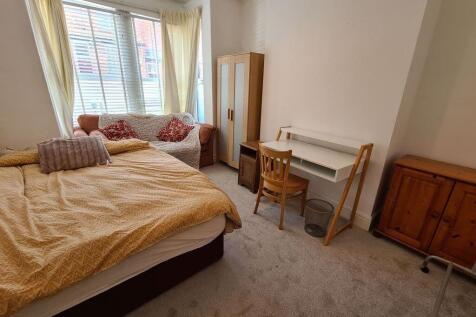 A cozy and tidy bedroom featuring a double bed,...