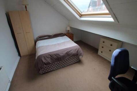 A cozy bedroom under a sloped roof with a doubl...