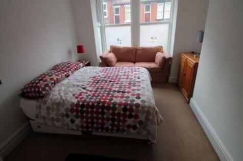 A cozy double bedroom with a double bed, a wind...