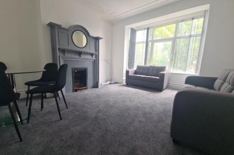 A spacious and well-lit living room with large ...