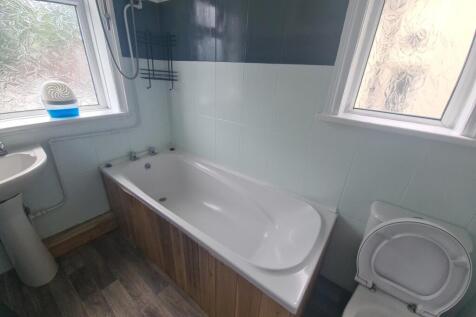 A spacious bathroom featuring a bathtub with cl...
