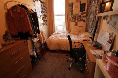 A cozy single bedroom featuring a bed situated ...