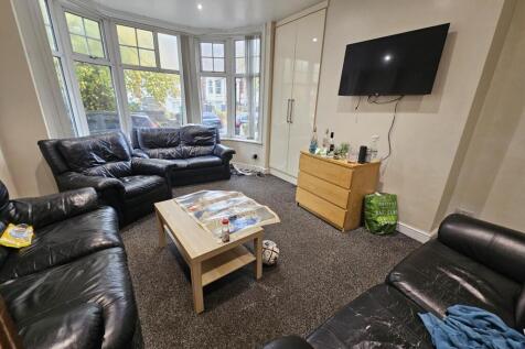 A spacious and well-lit living room featuring c...