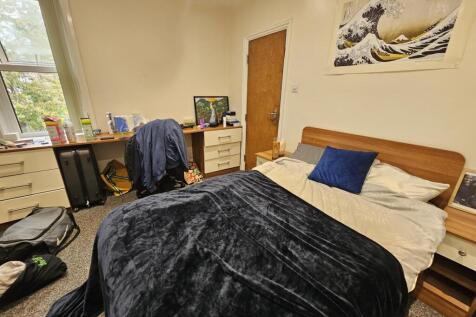 A cozy bedroom featuring a double bed with a da...