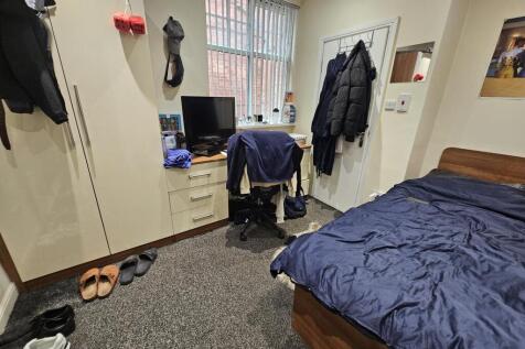 A cozy bedroom featuring a bed with a blue duve...