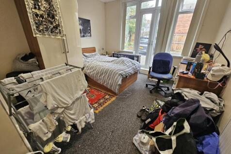 A spacious bedroom with a large bed, ample natu...