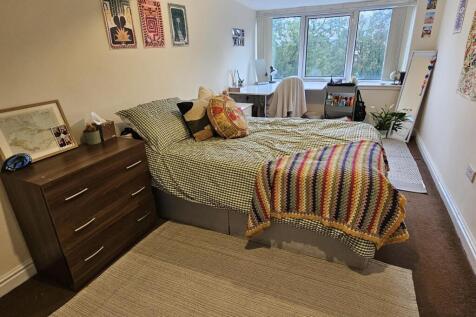 A spacious and well-lit master bedroom featurin...