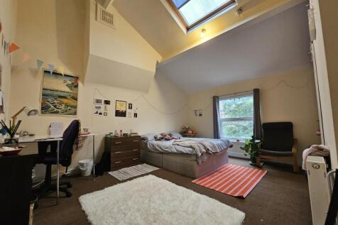 Spacious master bedroom featuring a large bed, ...