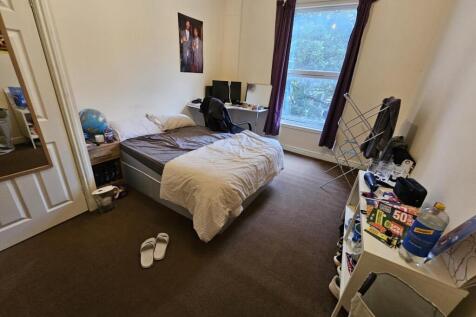A cozy bedroom featuring a double bed, a window...
