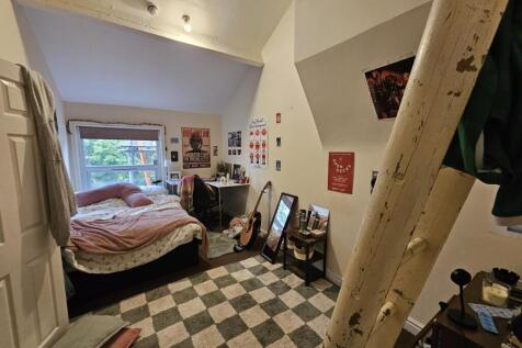 A cozy bedroom with a large window filling the ...