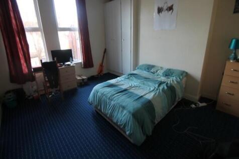 A cozy bedroom featuring a single bed with a bl...