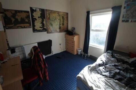 A cozy bedroom featuring a single bed with a cl...