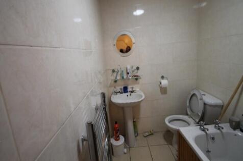 A compact bathroom with a toilet and small sink...