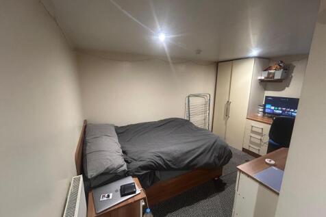 A cozy bedroom featuring a double bed with dark...