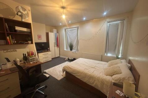 A well-lit bedroom featuring a double bed and a...