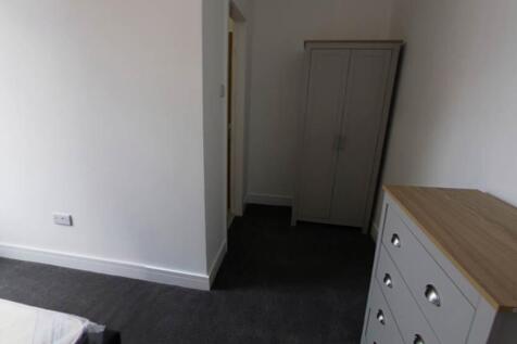 A clean and well-lit bedroom featuring a wardro...